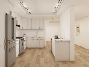 Open and airy kitchen with white shaker cabinets, marble countertops, and light wood flooring
