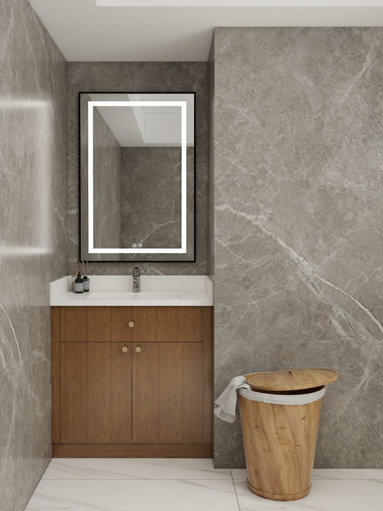 Bathroom vanity with a natural wood cabinet and white countertop, paired with a large framed mirror and set against stone-textured walls.