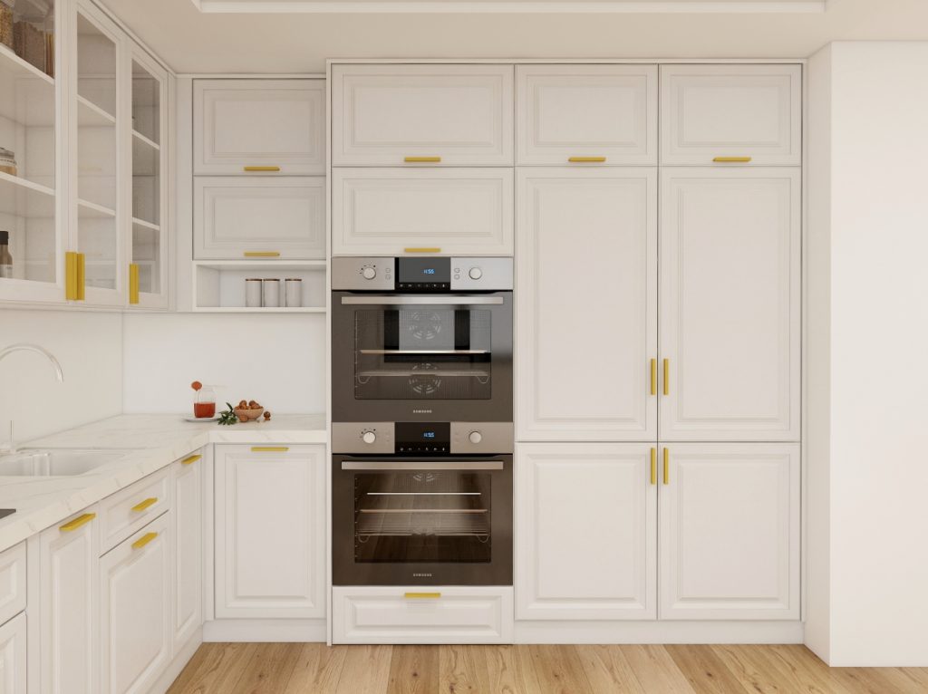 White kitchen cabinets with integrated double oven and gold handles