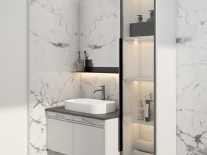 A floating bathroom vanity with white cabinets, a grey countertop, and glass display shelves, mounted against marble walls.