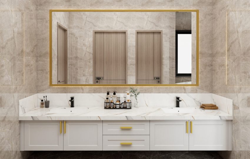 Modern double-sink vanity with a marble countertop, white cabinetry, and gold accents, complemented by a large gold-framed mirror.