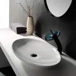 Contemporary white vessel sink with black drain and sleek modern faucet design