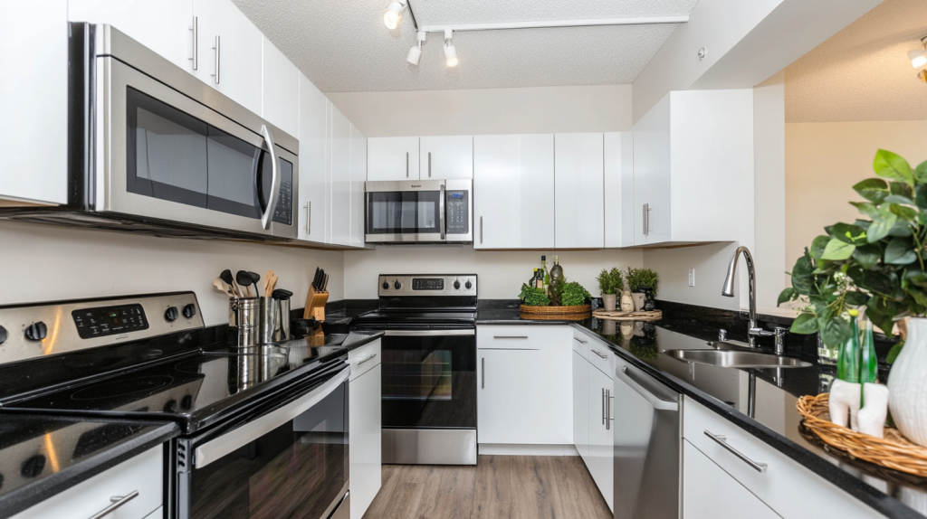 Modern U-shaped kitchen with glossy white cabinets, black countertops, stainless steel appliances, and compact urban layout.