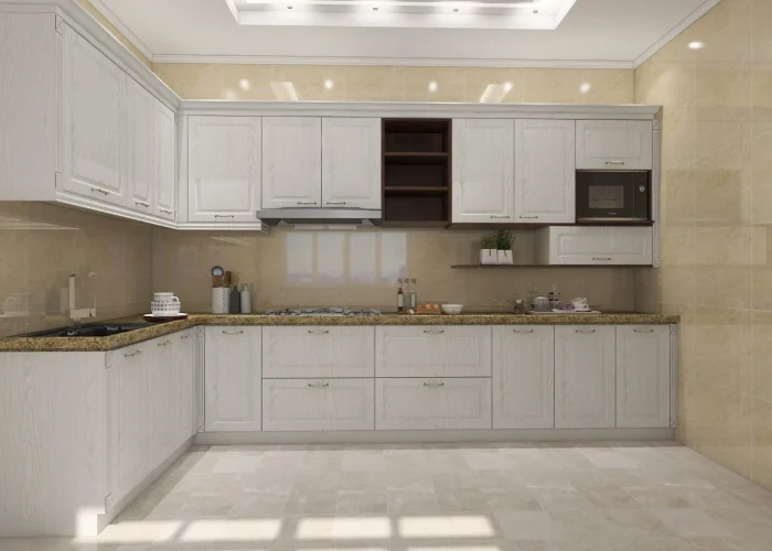Modern white PVC kitchen cabinets with a granite countertop and superior moisture resistance for durability.